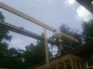 Carpenter setting a ridge beam over a new addition frame — Ice Dam Removal by Roofing Brothers in Langhorne