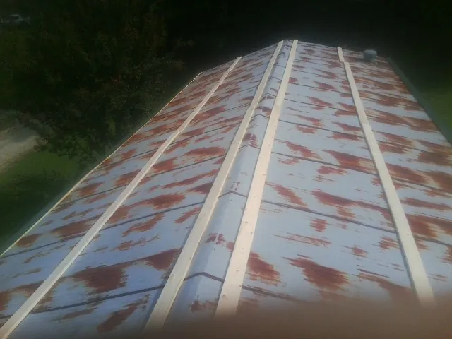 Rusted metal roof panels with new wood purlins before replacement — Storm Damage Roof Repair in Langhorne by Roofing Brothers