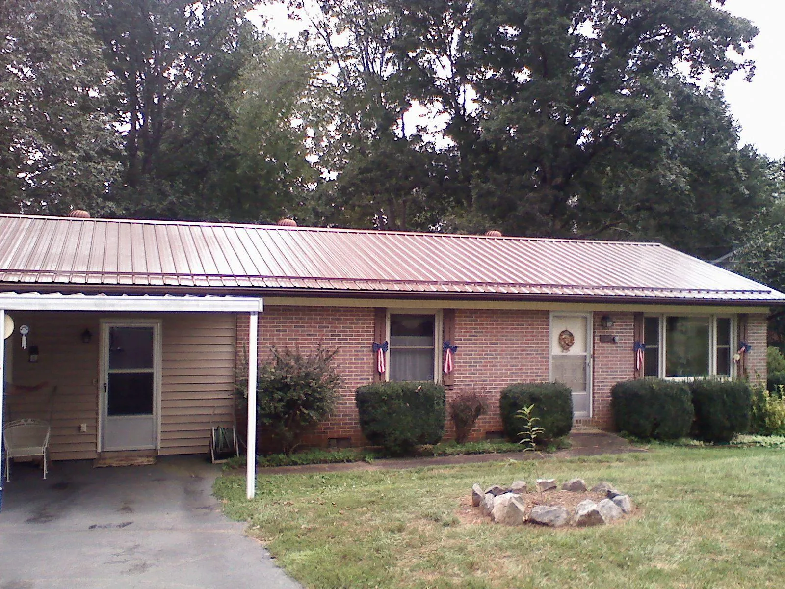 Bronze metal roof and carport on a brick ranch home — Roof Repair work by our crew in Langhorne